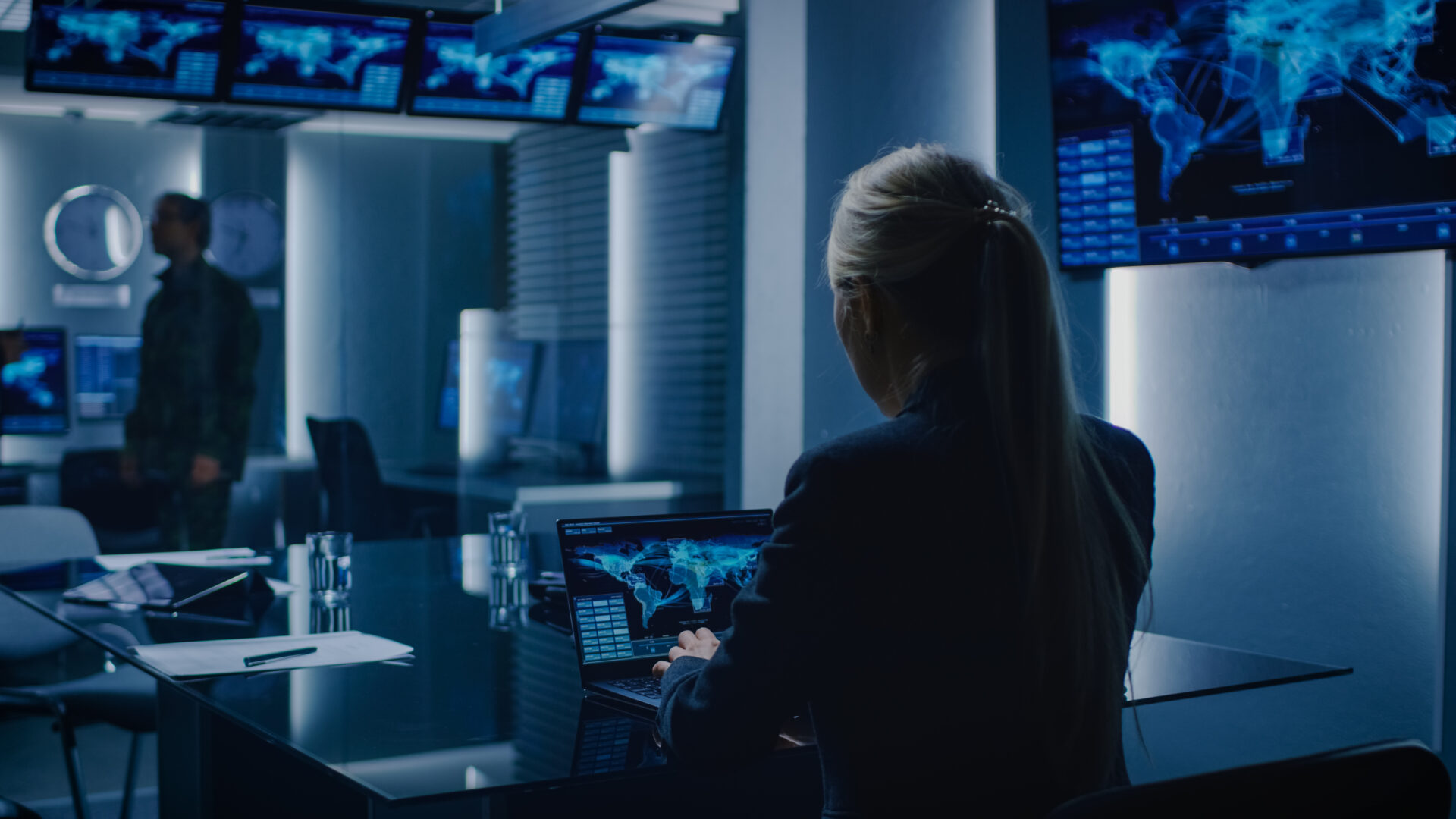 Female Special Agent Works on a Laptop in the Background Special